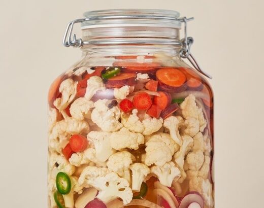 Glaskrukke med blomkål, gulerødder, løg og chili til syltning