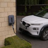 Elbil oplades ved en vægmonteret ladestander, muligvis en Zaptec Pro.